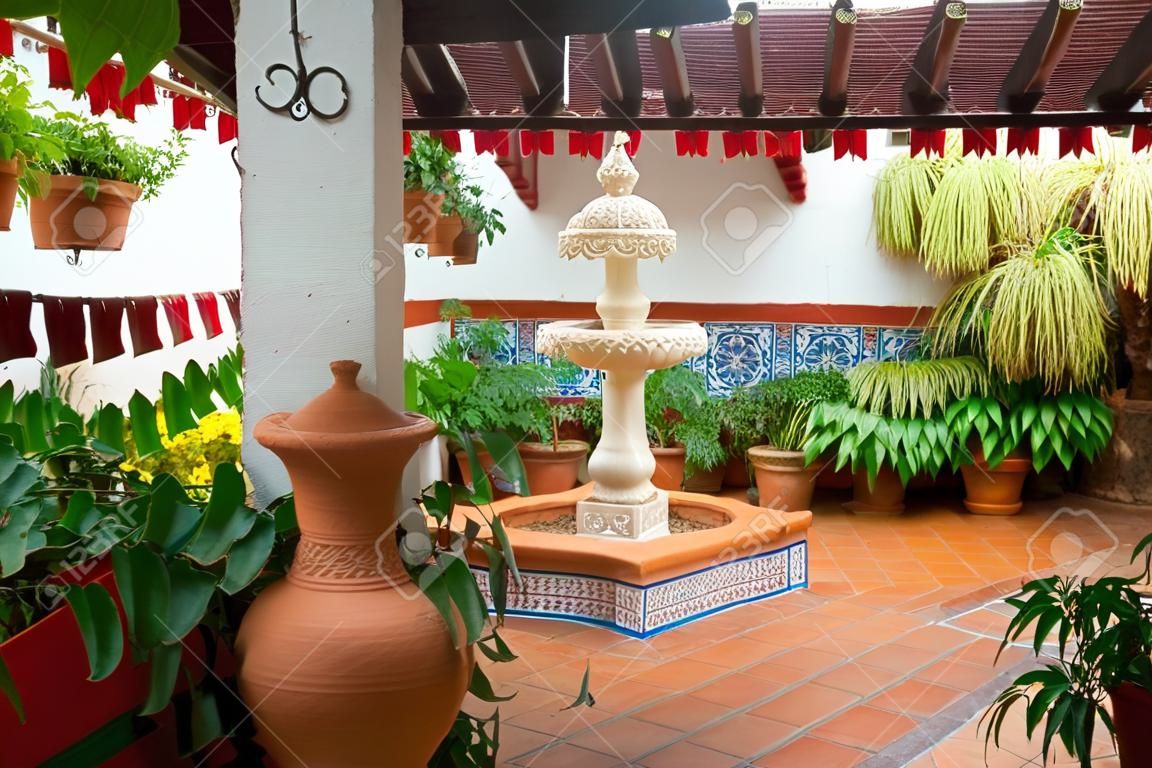 Detail van een typisch Andalusische patio met een waterfontein in het centrum en ingericht met verschillende soorten planten en potten. CÃ3rdoba, Andalusië, Spanje. Reizen en toerisme.
