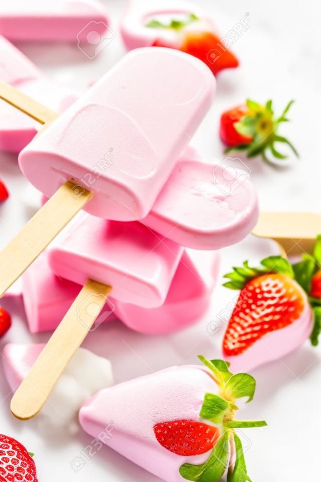Homemade popsicles with yogurt or ice cream with strawberries