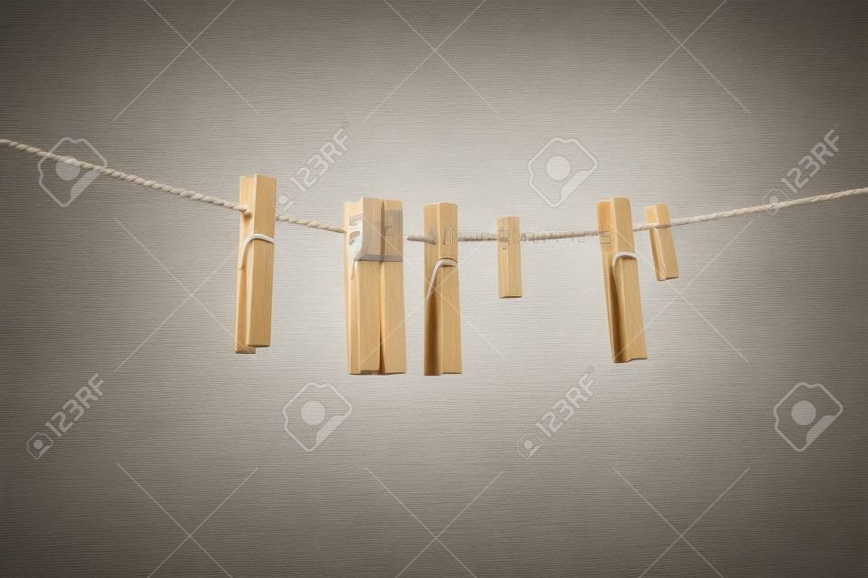 Wooden clothespin on the rope for drying clothes, housework concept