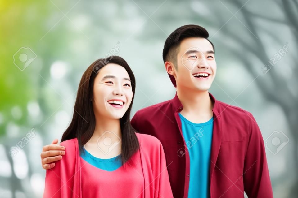 Portrait of young Chinese couple standing smiling outdoor