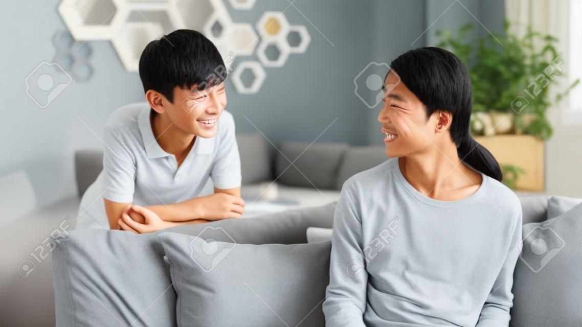 Asiatischer Teenager, der zuhause zu Hause seiner Mutter lächelt und spricht