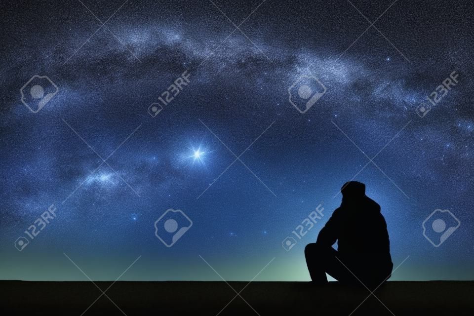 Homme regardant les étoiles. Seul homme regardant le ciel étoilé. Ciel de nuit.