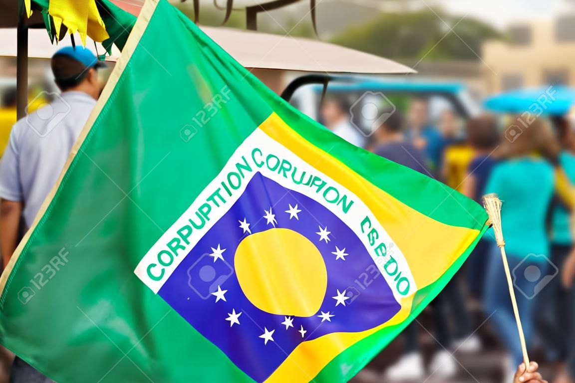 Man holding flag at street demonstration against corruption in Brazil. Democracy people meeting concept photo.