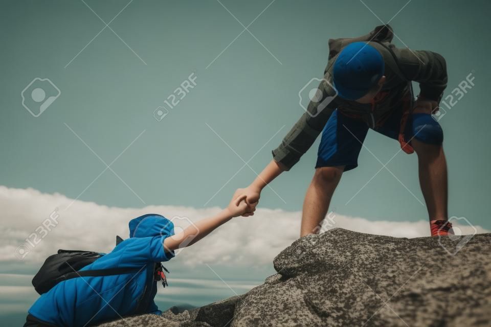 男の子は、自然の中でトップ山の女の子を助ける