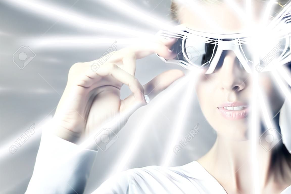 Kobieta w okularach wirtualnych rzeczywistości i promieni hologram