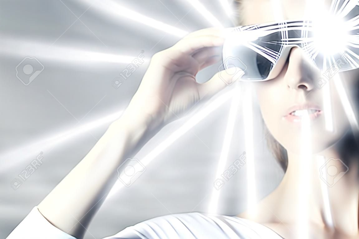 Woman in virtual reality glasses and hologram rays