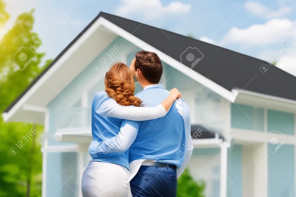 Szczęśliwa para spacerująca patrząc na swój dom