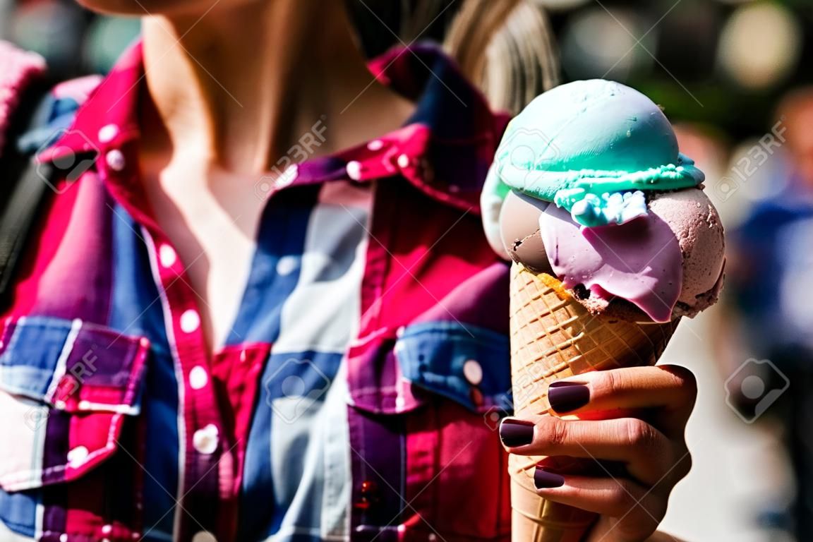 Girl Holding ice cream in the cone. Summer Concept.