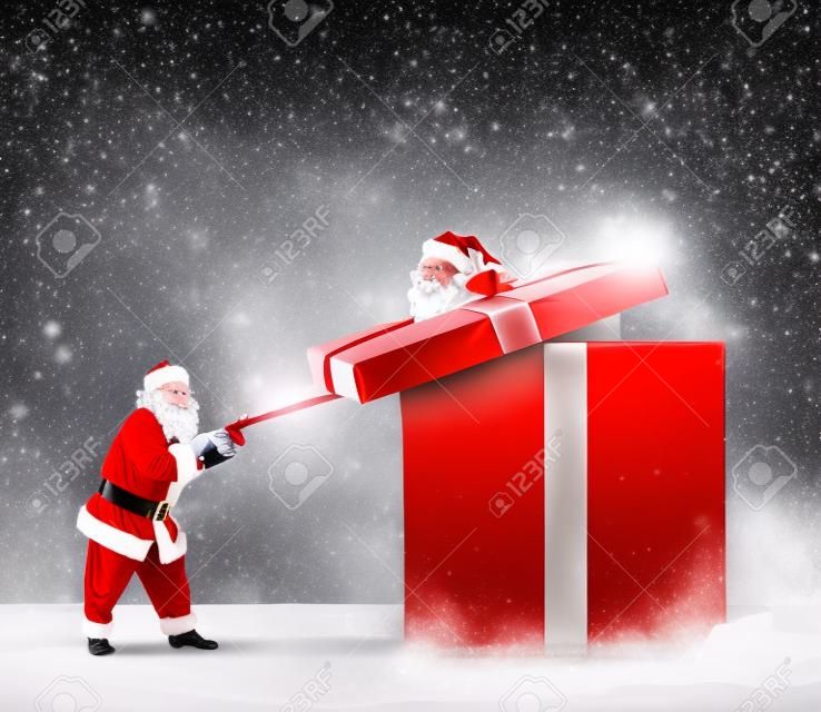 De kerstman opent een groot rood cadeau