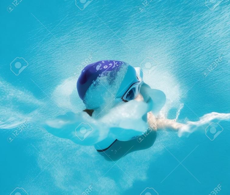 Девушка плавает в бассейне в плавании вольным стилем