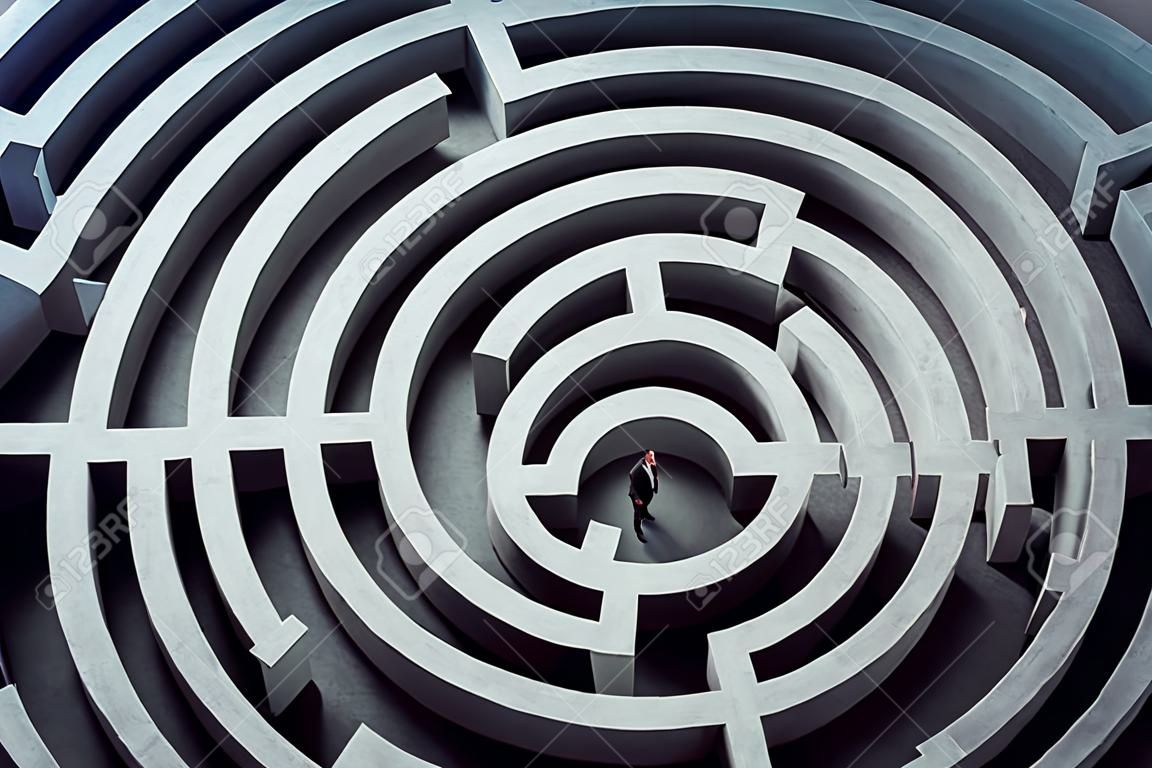 L'uomo d'affari confuso pensa a come trovare il modo giusto per uscire da un grande labirinto