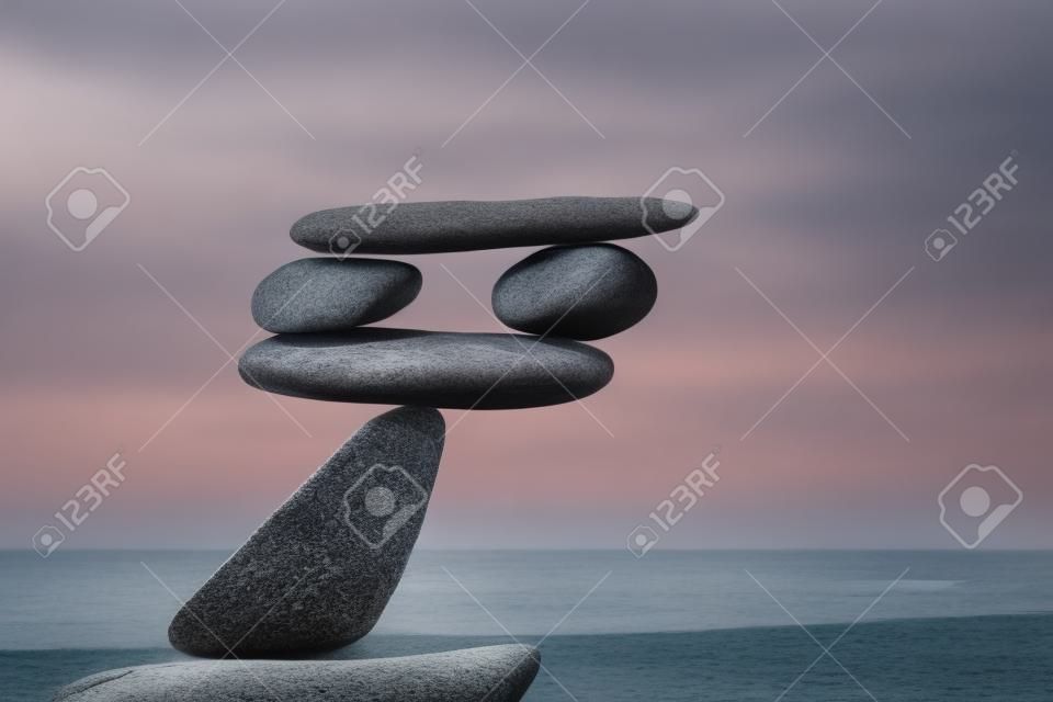 Equilibrado Rock Zen no fundo do mar. O conceito de risco de queda e equilíbrio instável