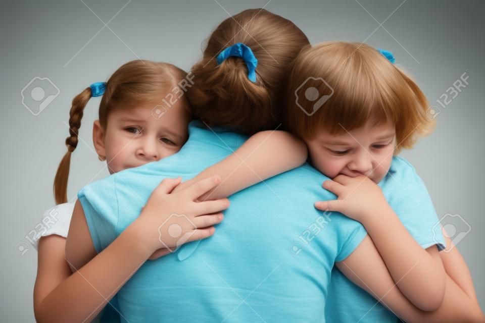 crianças tristes abraçando sua mãe