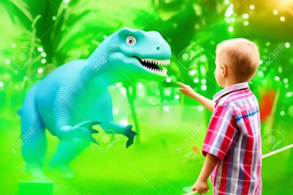 petit garçon jouant dans le parc aventure dino. Concept d'enfance heureuse.