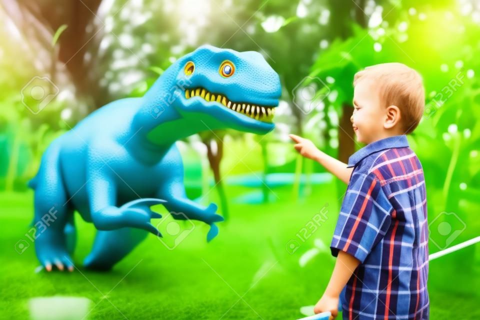 petit garçon jouant dans le parc aventure dino. Concept d'enfance heureuse.