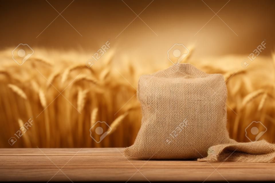 屋外のテーブルの上の黄麻布袋に入った小麦粒