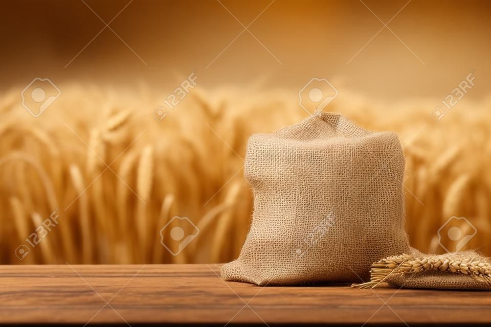 屋外のテーブルの上の黄麻布袋に入った小麦粒