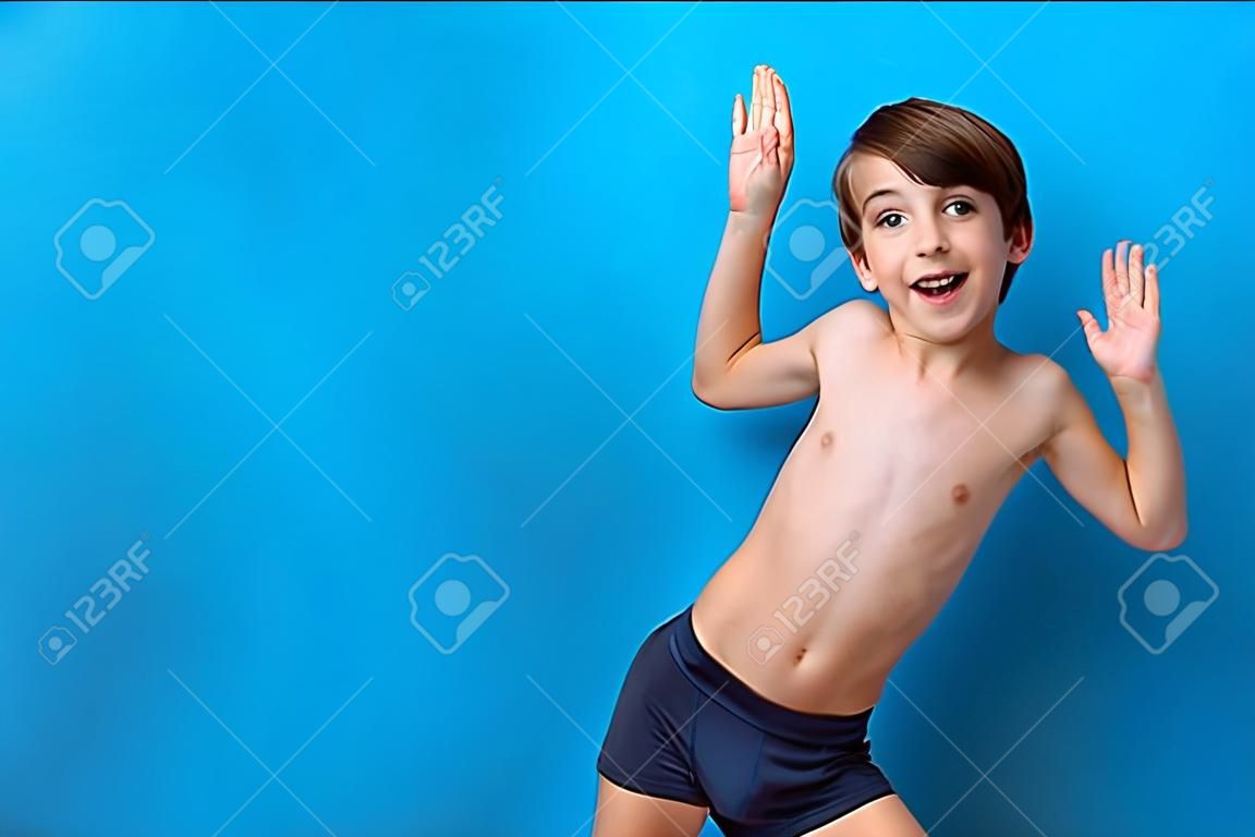 Chico alegre turista de 9 años de edad con un fondo azul. Entretenimiento marino. Banner turístico con niño