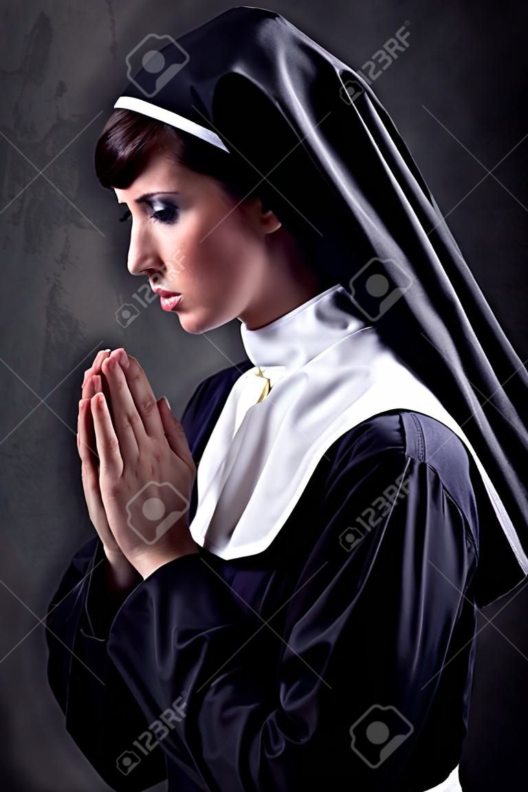 Monja joven y atractiva orando