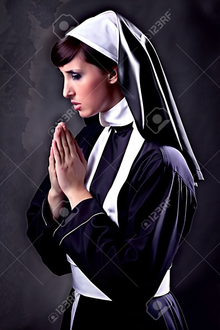 Monja joven y atractiva orando
