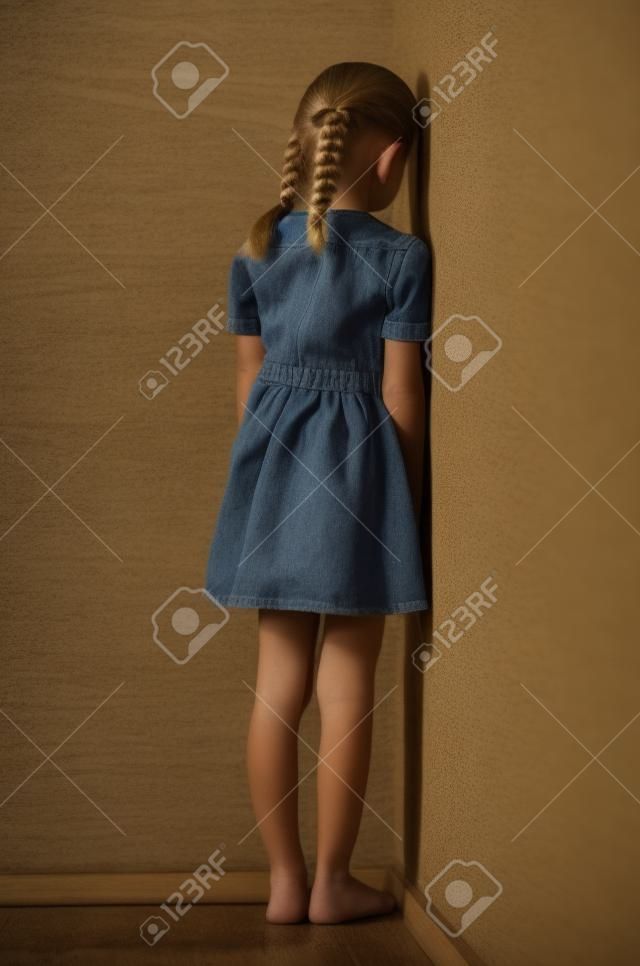 小女孩與她的金發辮子站在角落面壁生悶氣或懲罰不法行為