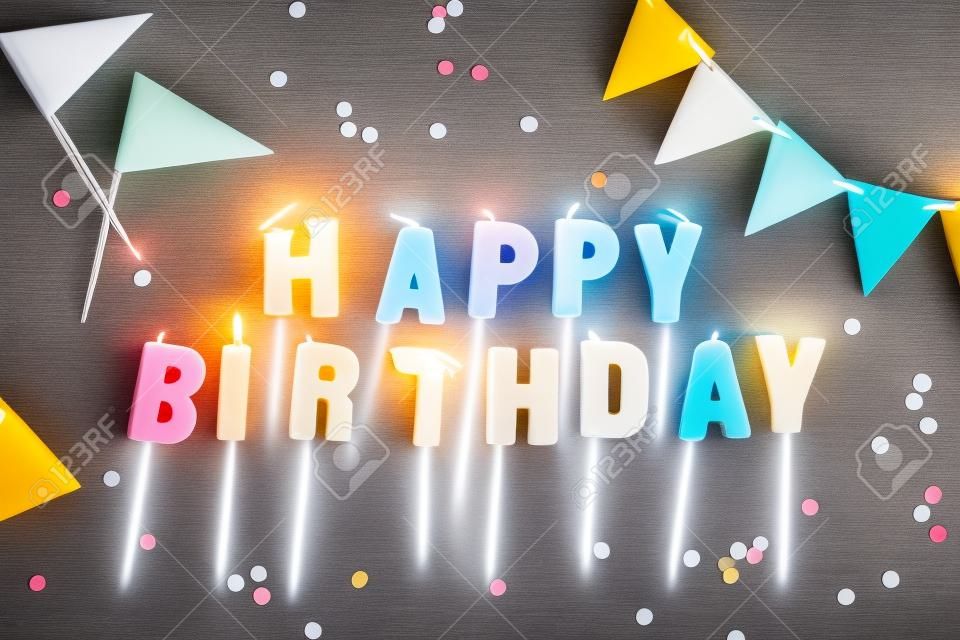 Concepto de cumpleaños - velas con letras feliz cumpleaños y confeti