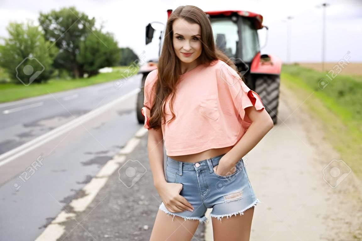 Portret van een jong mooi meisje in jeans shorts op een landelijke weg