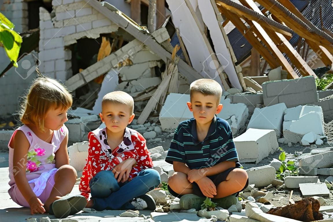 lLittle orphans were left without housing and stand near the ruins of the building as a result of a military conflict, a fire and an earthquake. Photo production.