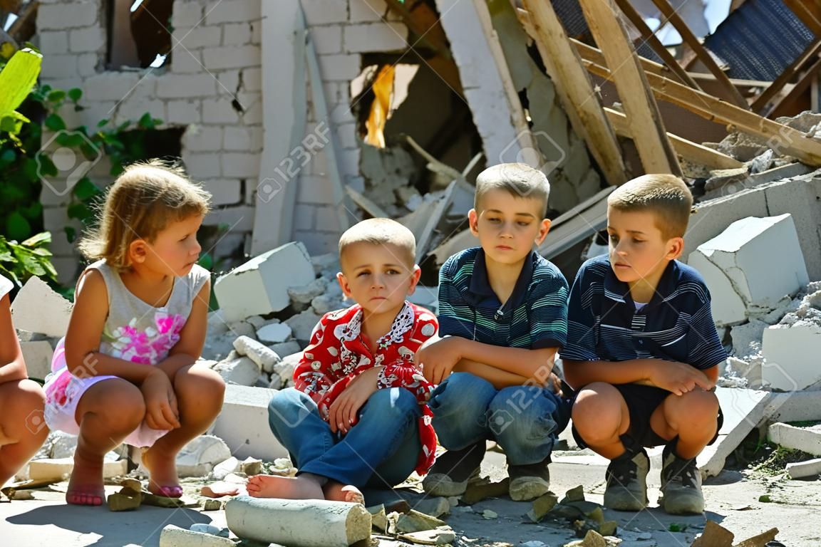 lPequeños huérfanos se quedaron sin vivienda y permanecen cerca de las ruinas del edificio como resultado de un conflicto militar, un incendio y un terremoto. Producción fotográfica.