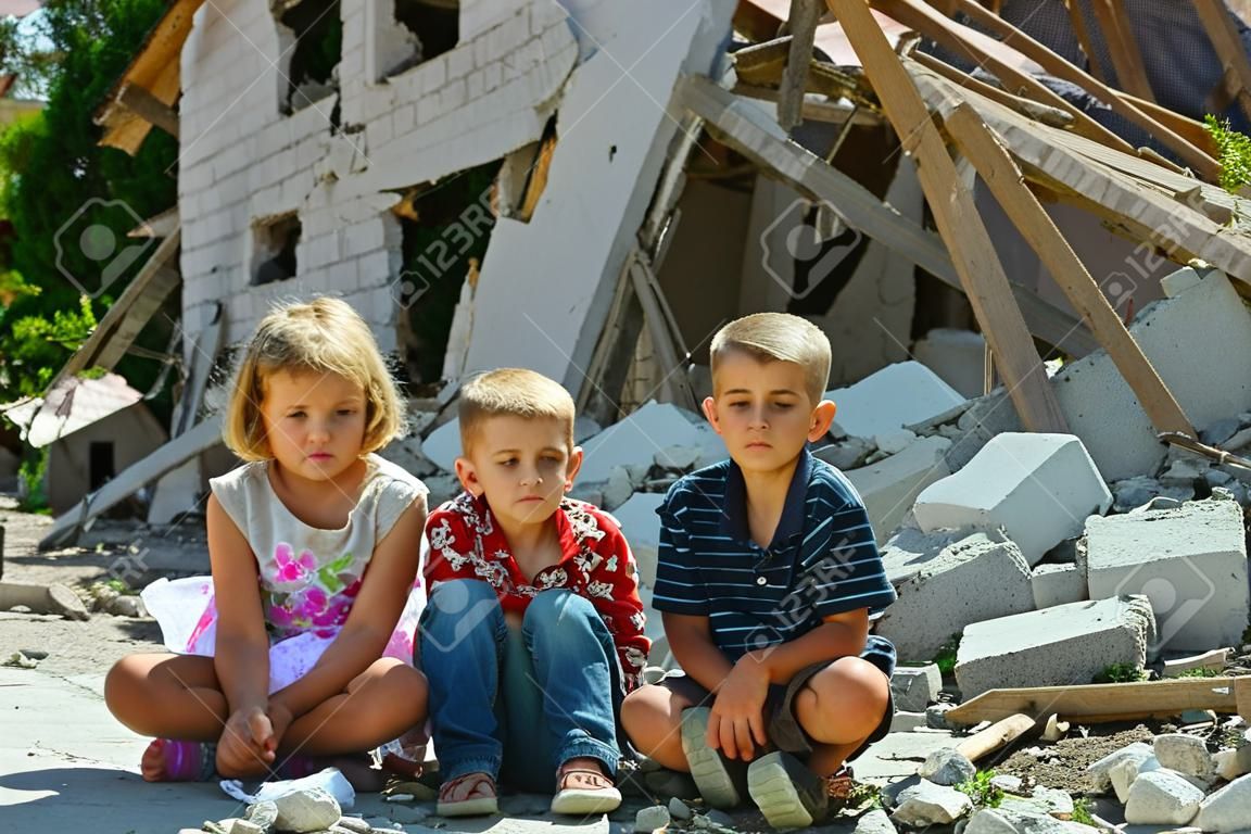 lPequeños huérfanos se quedaron sin vivienda y permanecen cerca de las ruinas del edificio como resultado de un conflicto militar, un incendio y un terremoto. Producción fotográfica.