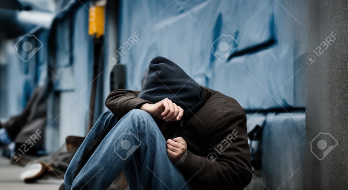 Caucasian homeless man sitting and thinking.