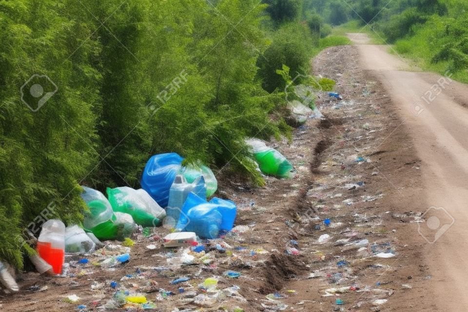Illegale Mülldeponie auf einer unbefestigten Straße, Plastik und anderen Abfällen. gefährliche Verschmutzung der Natur.