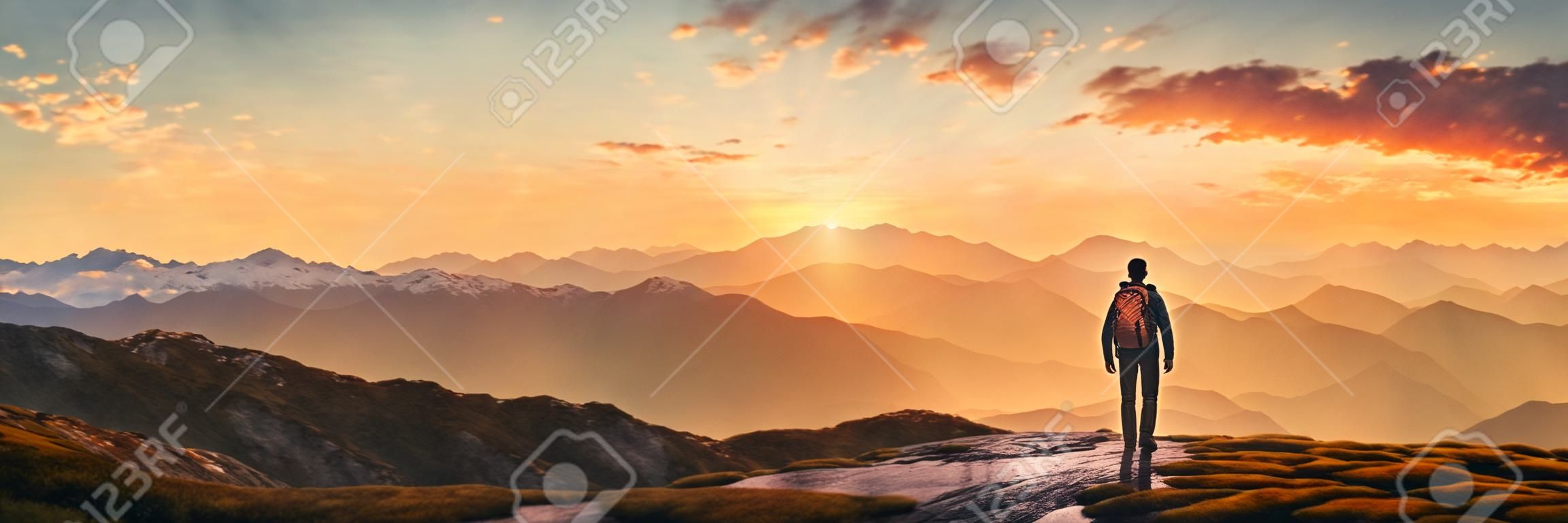 Wandelaar in de bergen bij zonsondergang panoramisch uitzicht