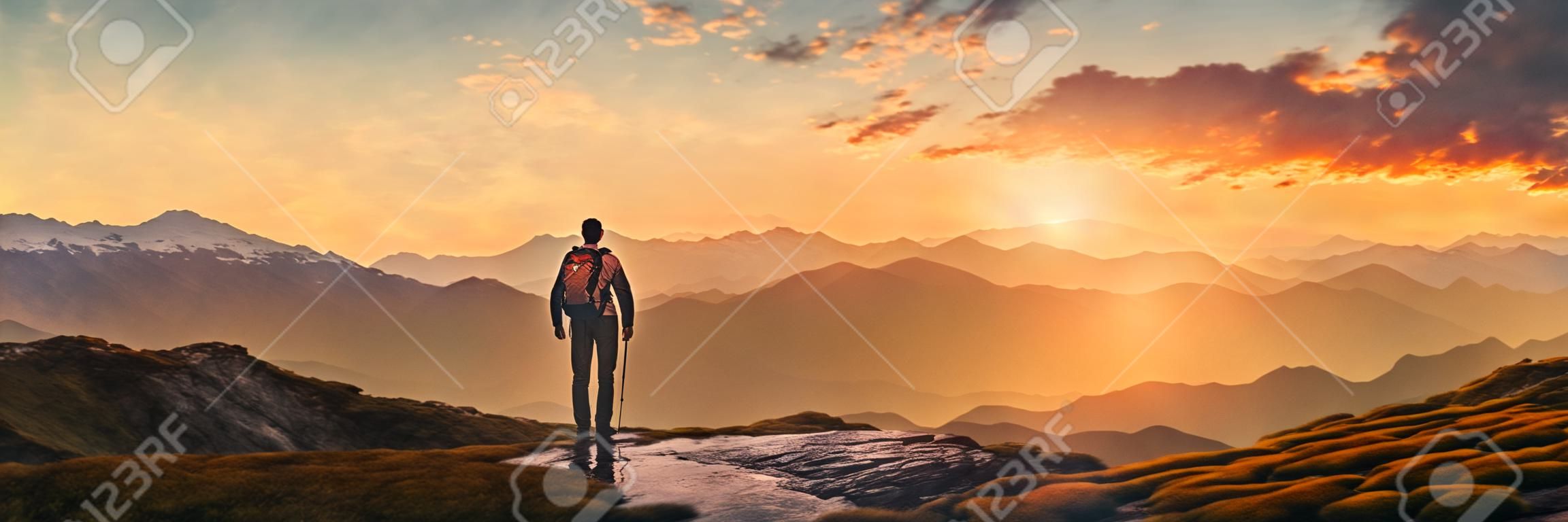 Wandelaar in de bergen bij zonsondergang panoramisch uitzicht