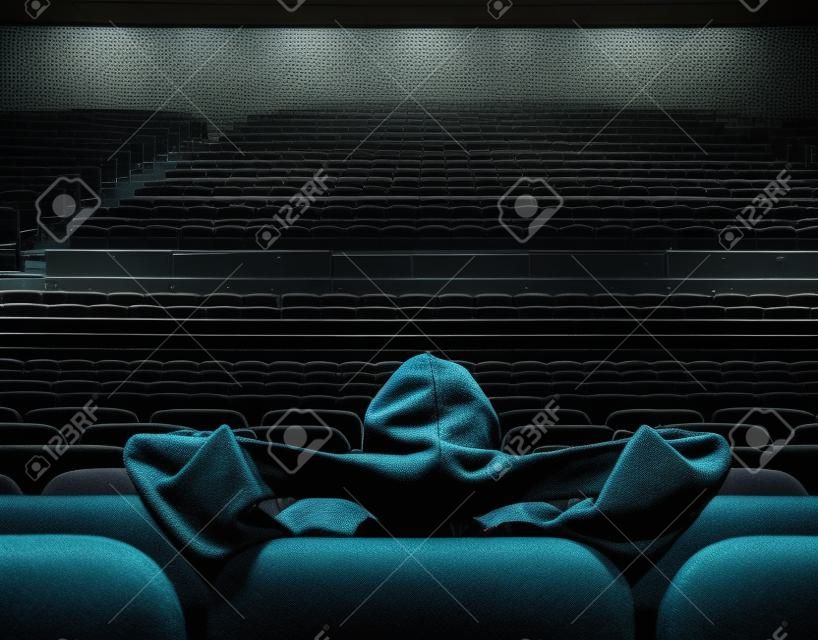 человек, сидящий в одиночестве в пустой кинозал
