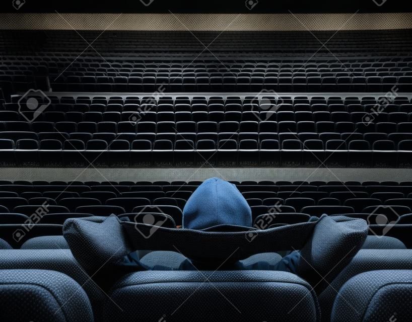 man sitting alone in empty cinema hall