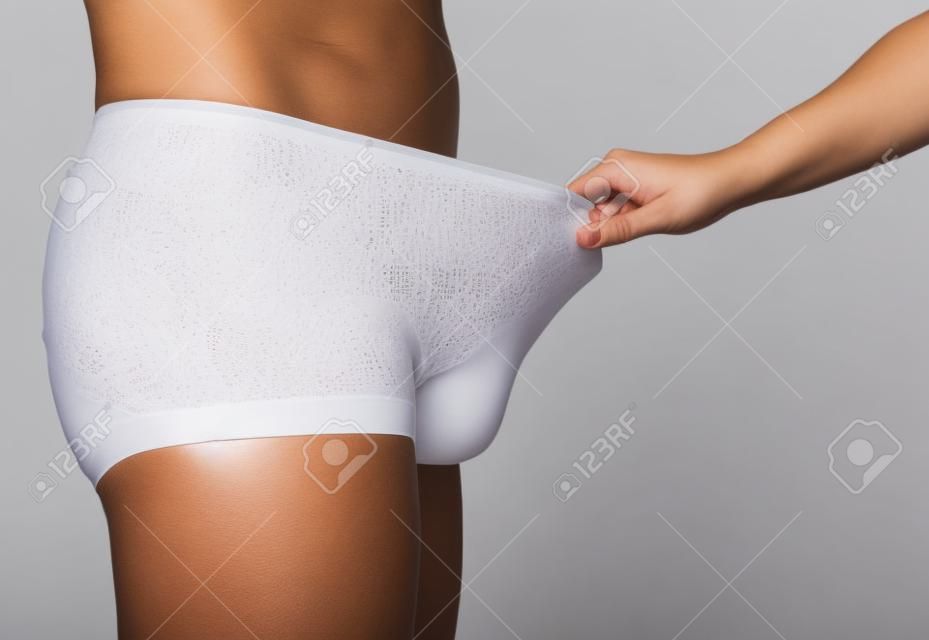 Women's panties on his finger at the man. On a white background