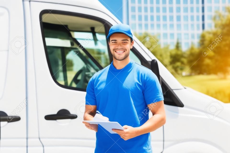 Junger glücklicher männlicher Worker Vor Truck schriftlich über die Zwischenablage