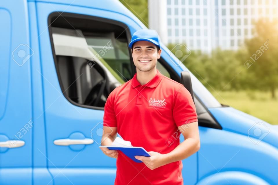 Junger glücklicher männlicher Worker Vor Truck schriftlich über die Zwischenablage