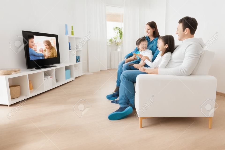Young family watching TV together at home