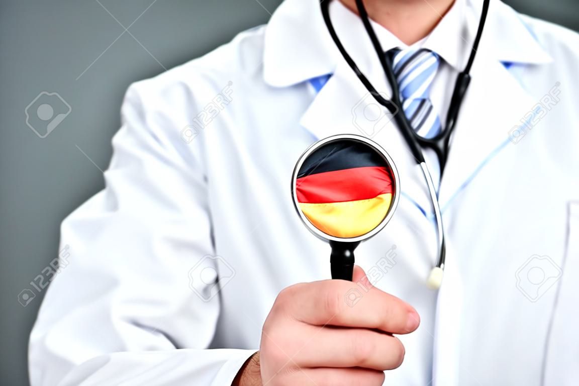 Close-up van een dokter vasthouden Stethoscoop met Duitse vlag op borststuk