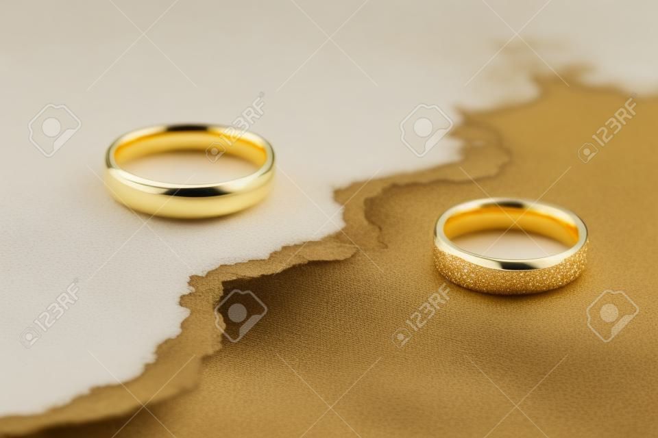 Close-up Of Two Golden Wedding Rings On Cracked Surface