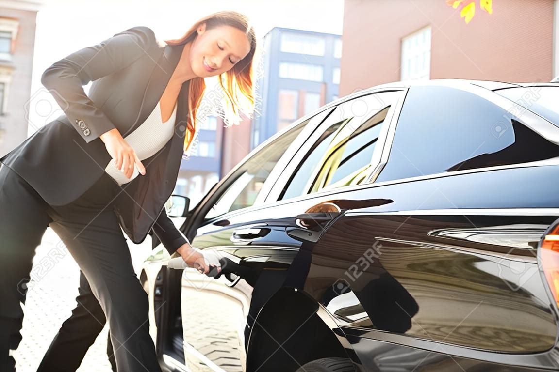 Autista che apre la porta dell'auto privata per donna d'affari