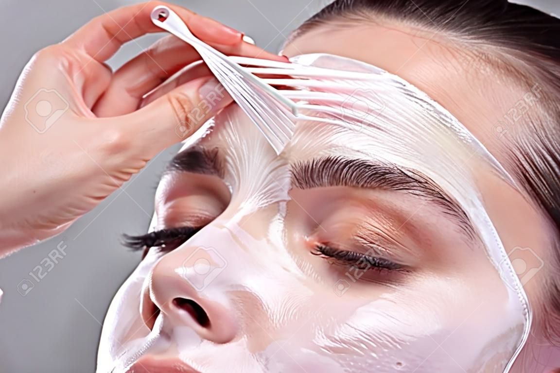 Portret van een mooie jonge vrouw verwijderen Peeling masker van haar gezicht