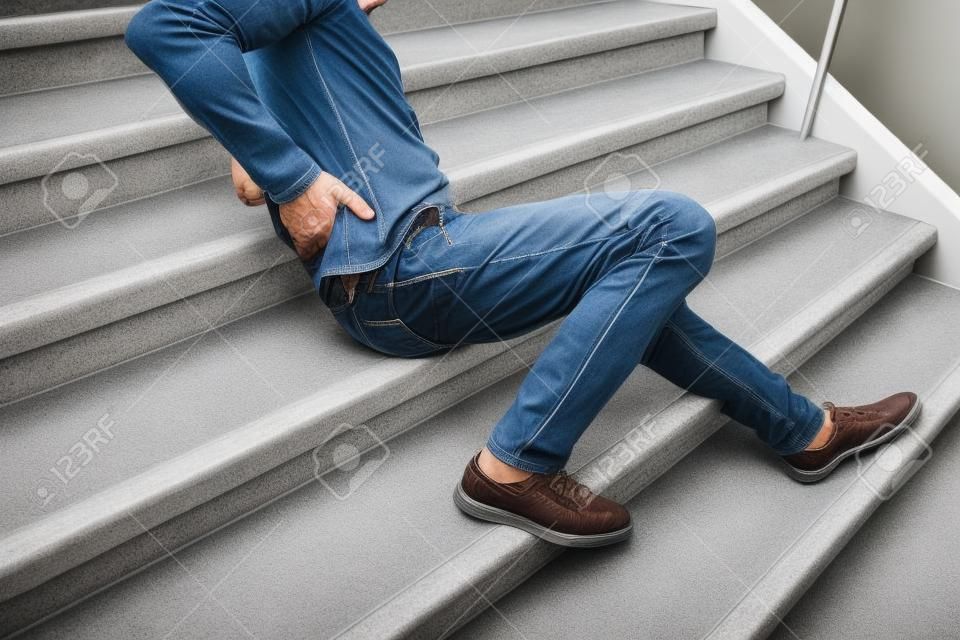 Homme mûr allongé sur un escalier après un accident de glissade et de chute