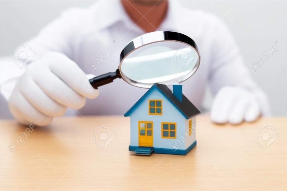 Inspekcja domu lub domu za pomocą szkła powiększającego. podatek i ubezpieczenie