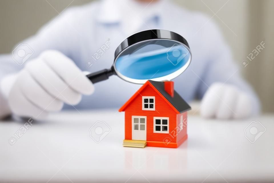 Inspekcja domu lub domu za pomocą szkła powiększającego. podatek i ubezpieczenie