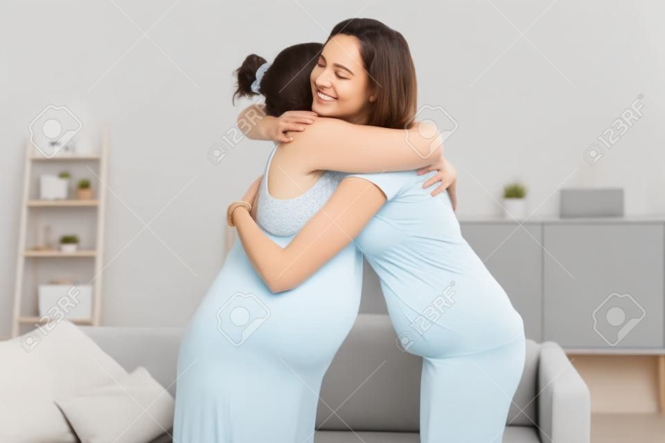 Happy Pregnant Women Hugging At Home With Doula
