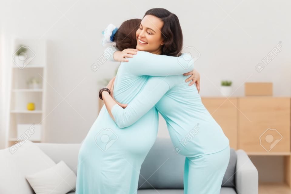 Happy Pregnant Women Hugging At Home With Doula