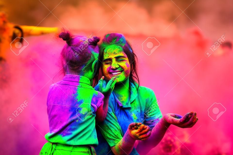 mother and daughter are played on the nature of the colors. two playing with the color in holi festival